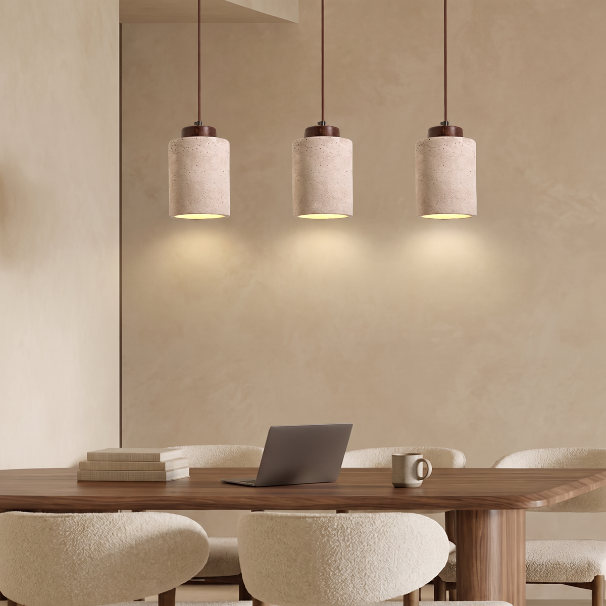 Three travertine pendant lights above a walnut dining table with cream boucle chairs against a warm beige limewash wall
