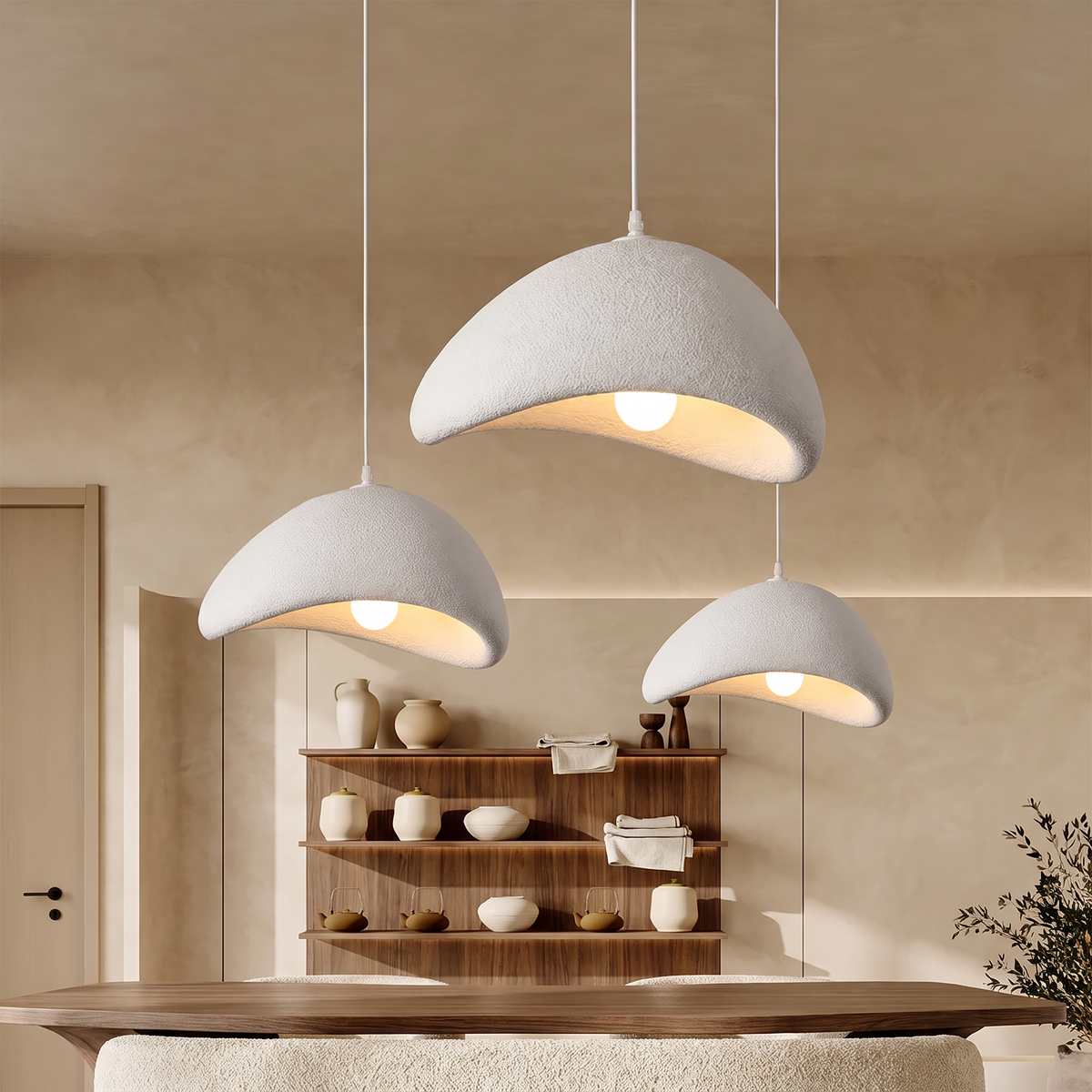 Wabi-Sabi pebble pendant lights in white above a wooden dining table against a warm beige wall