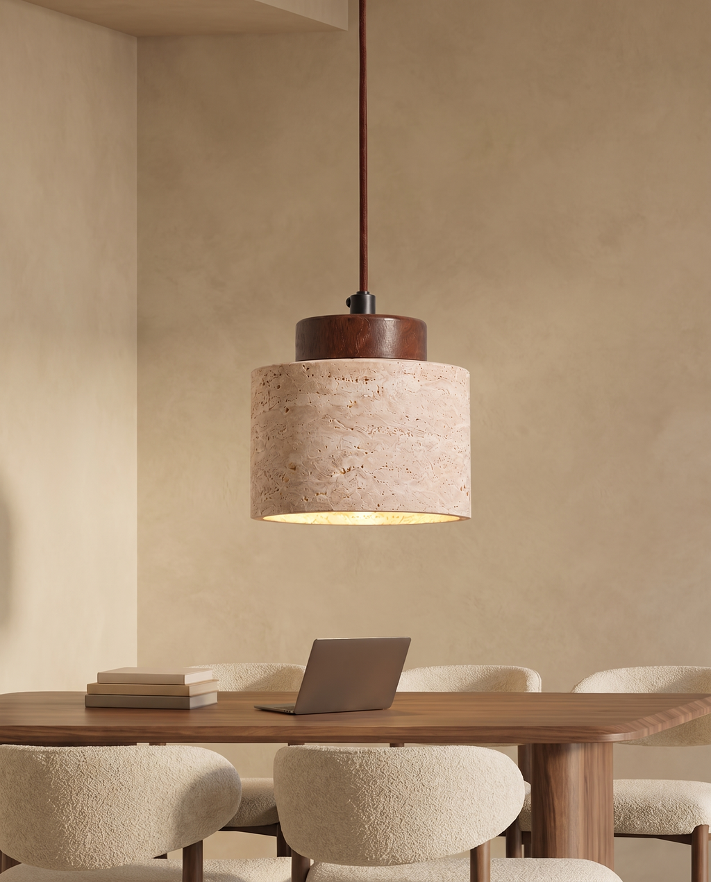 Travertine pendant light above a walnut dining table with cream boucle chairs against a warm beige wall