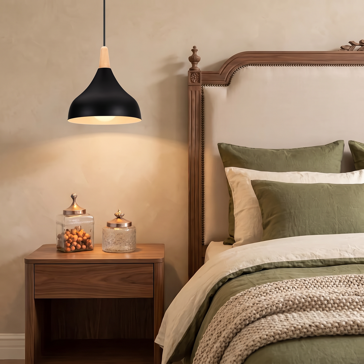 Black teardrop pendant light with wooden top beside a bed with olive green linen against a warm beige wall