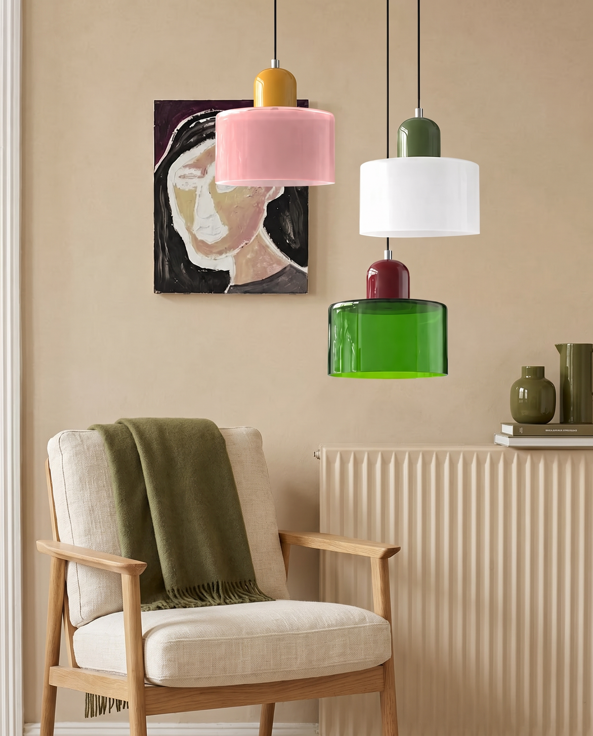 Three two-tone glass drum pendant lights with an oak armchair against a warm beige wall