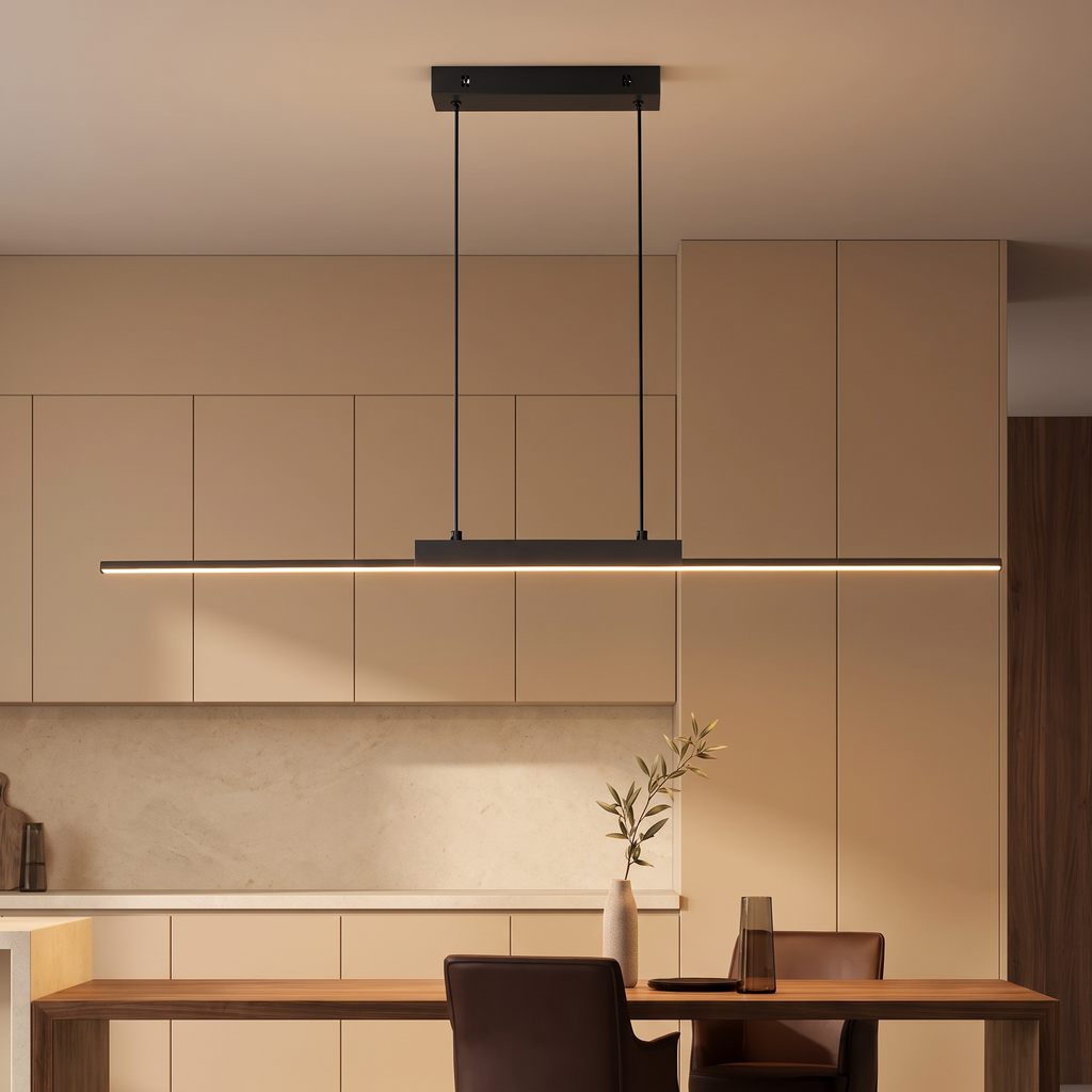 Minimalist black linear LED pendant light glowing warm white above a walnut table against warm beige cabinets