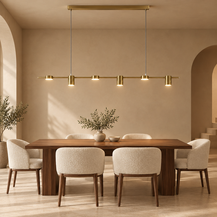 Brushed gold linear LED spot pendant light above a dining table in a warm arched room