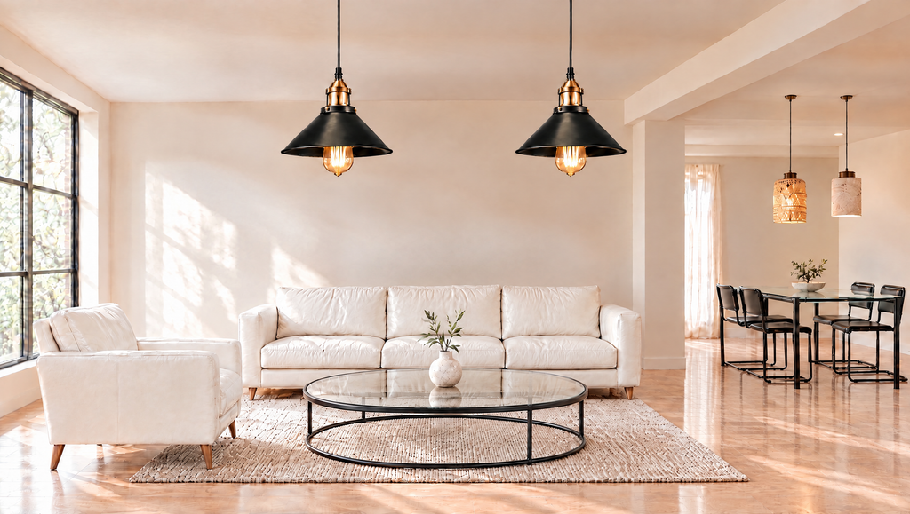 Living room with two black and brass pendant lights above a round glass coffee table